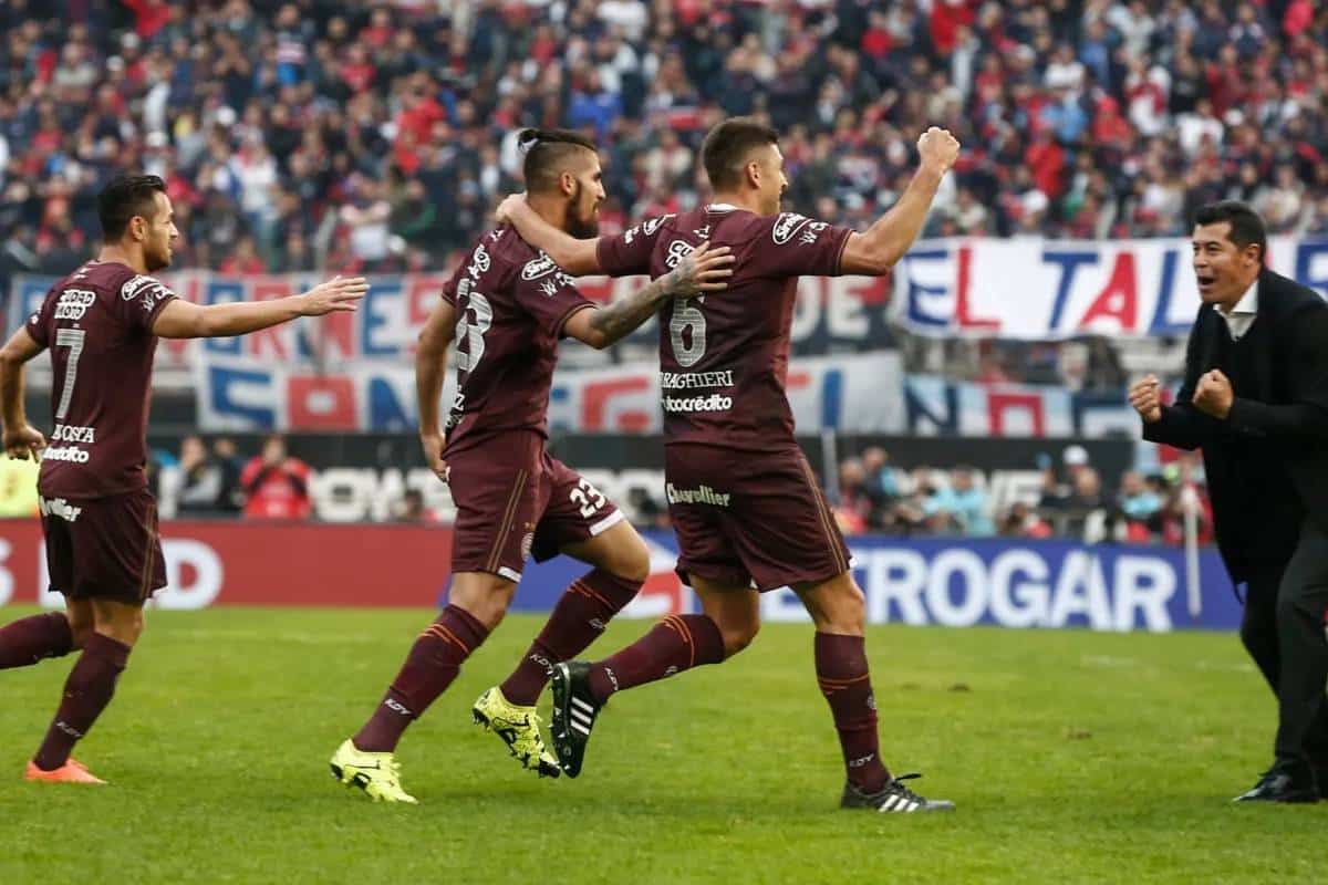 Los jugadores de Lanús abrazan a Jorge Almirón, el estratega de un equipo que daba miedo