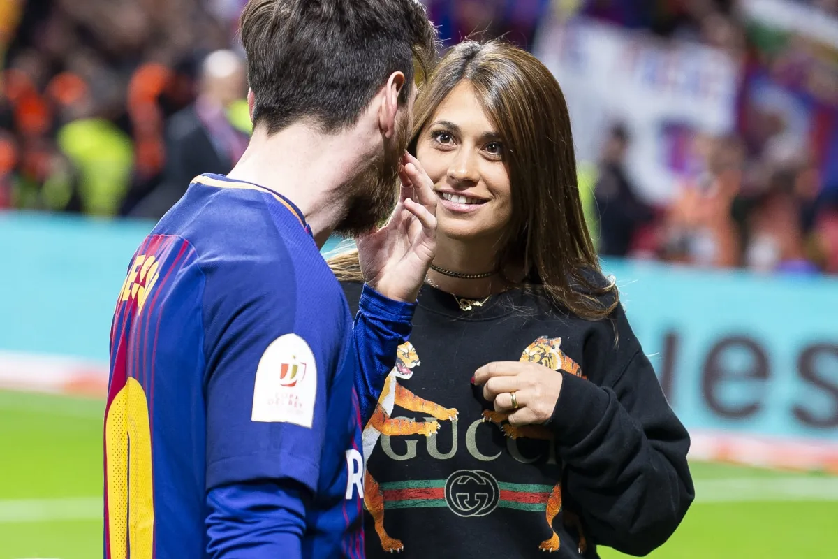 Antonela Roccuzzo y Lionel Messi en un campo de fútbol en España